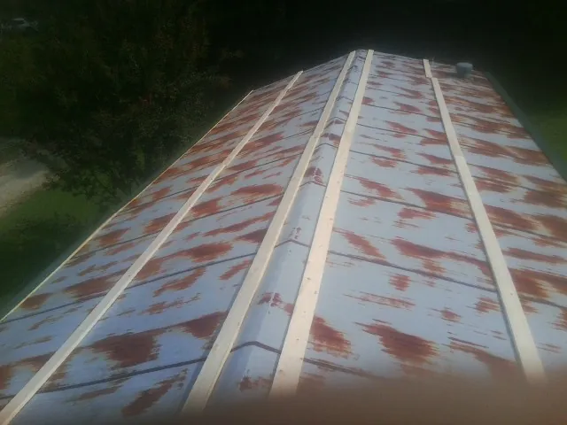 Rusted metal roof panels with new wood purlins before replacement — Storm Damage Roof Repair in Fultondale by Roofing Brothers