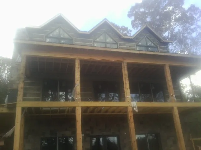 Dormers and porch framing on a large log home under construction — Roof Coating work by our crew in Fultondale