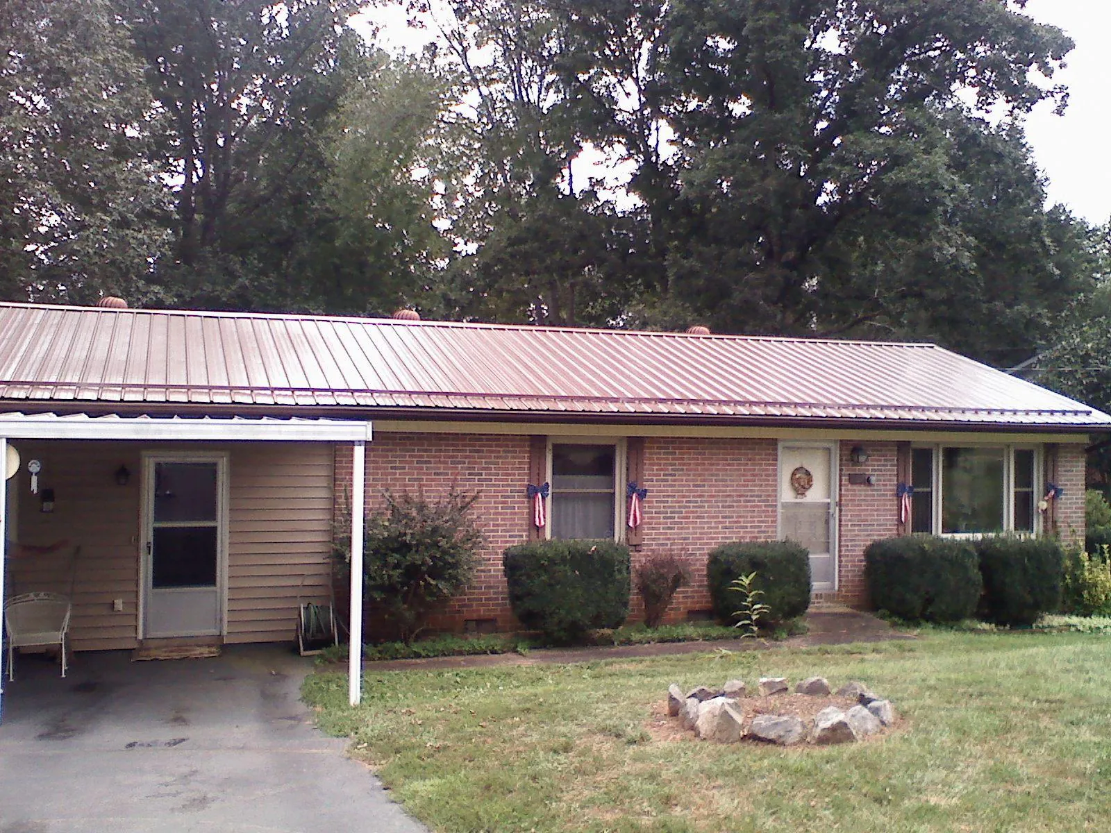 Bronze metal roof and carport on a brick ranch home — Roof Repair work by our crew in Fultondale