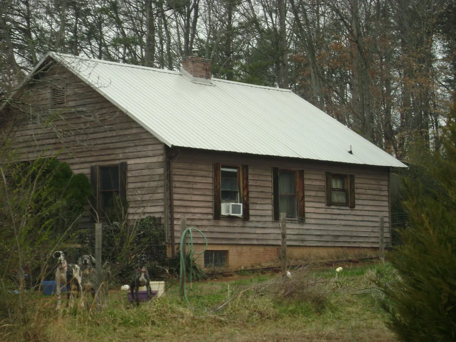 White metal roof on an old wood sided farmhouse, from a Metal Roof Installation job in Fultondale
